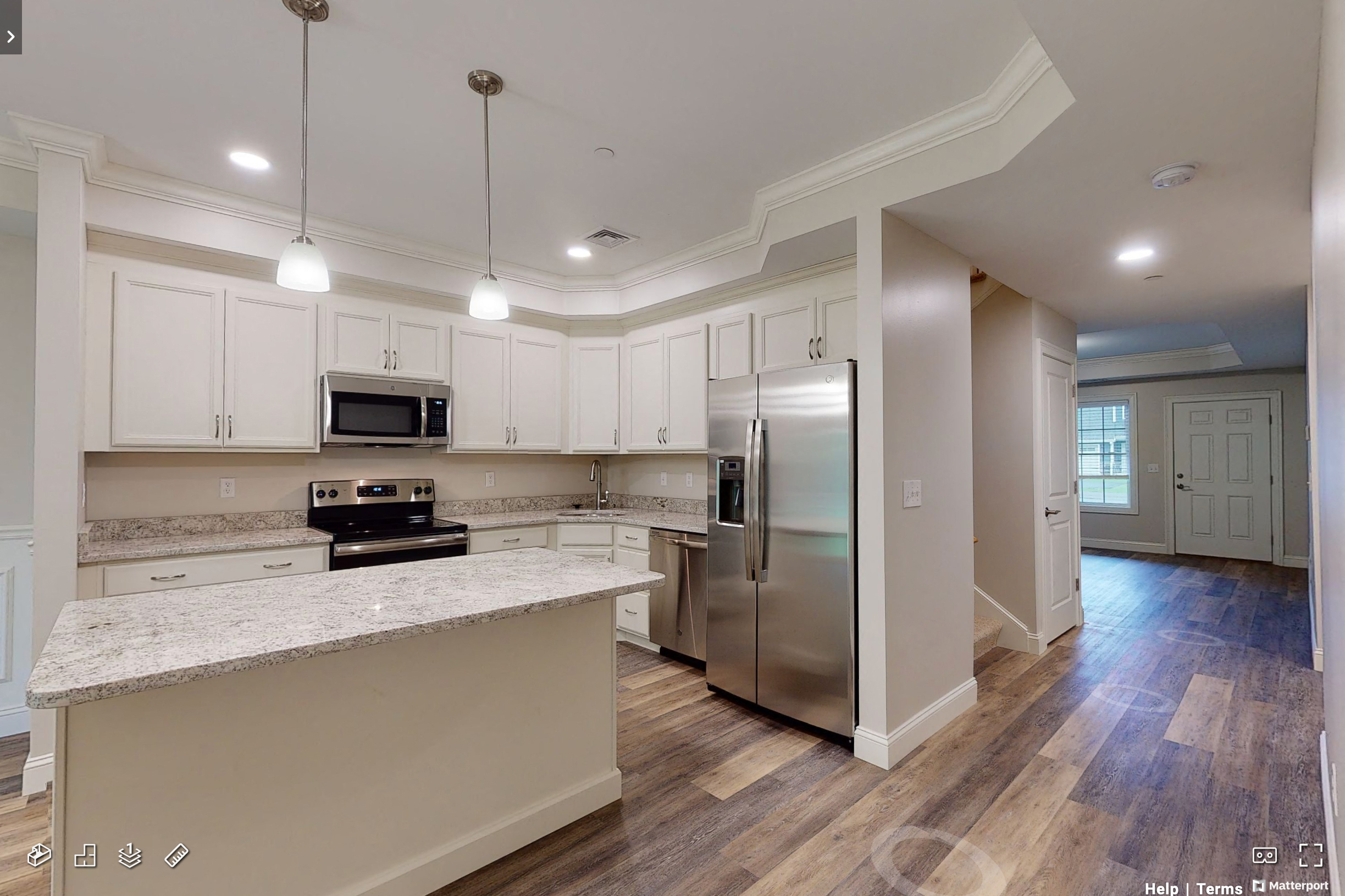 a kitchen with white cabinets and a stainless steel refrigerator
